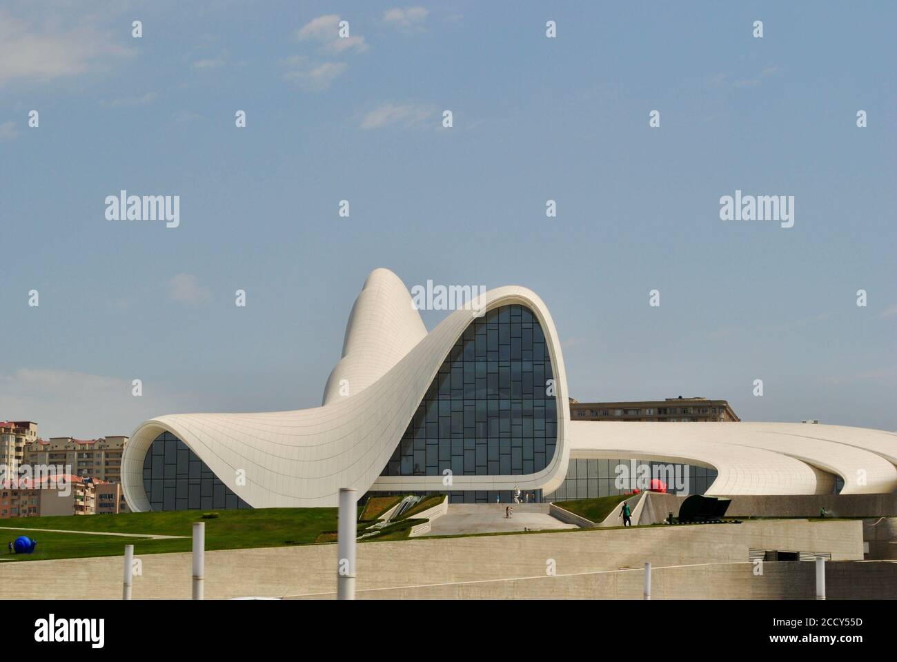 Baku Azerbaigian. L'entrata del Centro Heydar Aliyev, in stile curvo e scorrevole progettato da Zaha Hadid con edifici di quartiere come sfondo. Foto Stock