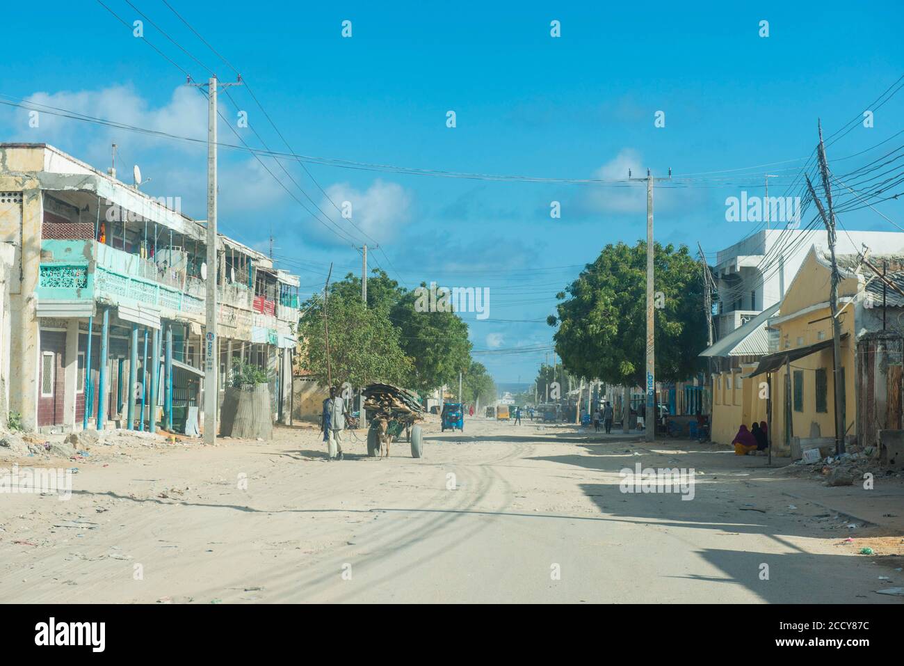 Donna somala davanti alle case distrutte di Mogadiscio, Somalia Foto Stock