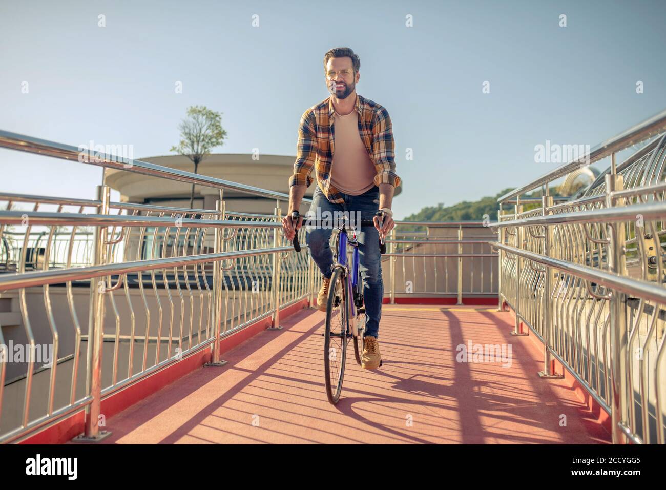 Gioioso uomo di successo in bicicletta in giornata di sole Foto Stock