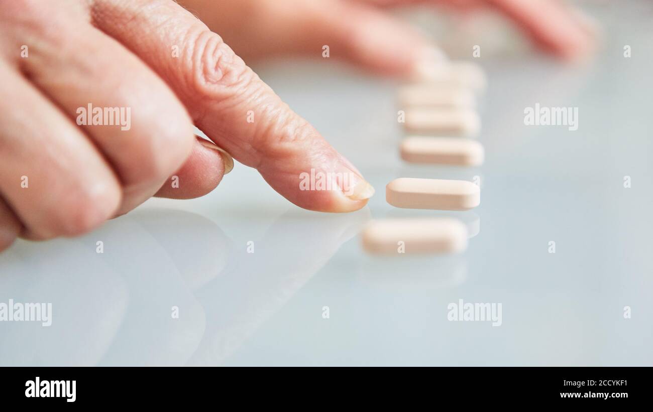 Il paziente punta il dito sulle compresse come segno di farmaco dipendenza Foto Stock