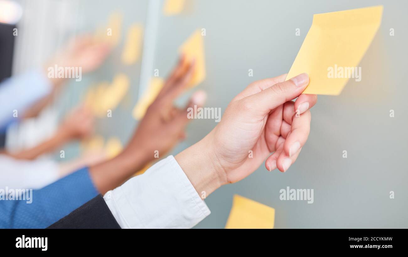 Gli uomini d'affari scrivono le idee sulle note appiccicose nel brainstorming creativo officina Foto Stock