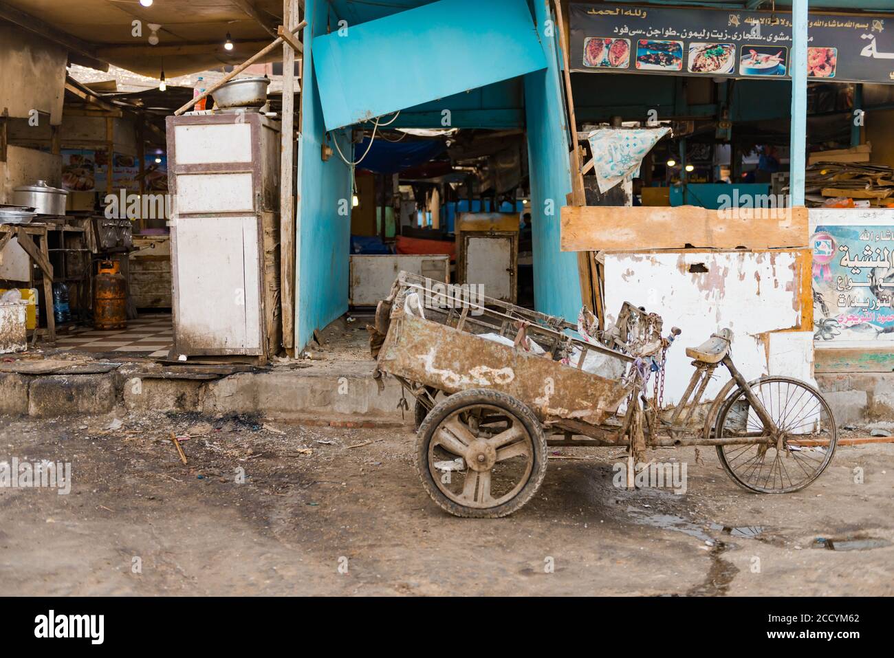 bicicletta rustica d'epoca con rimorchio in costruzione del mercato del pesce della città sullo sfondo Foto Stock