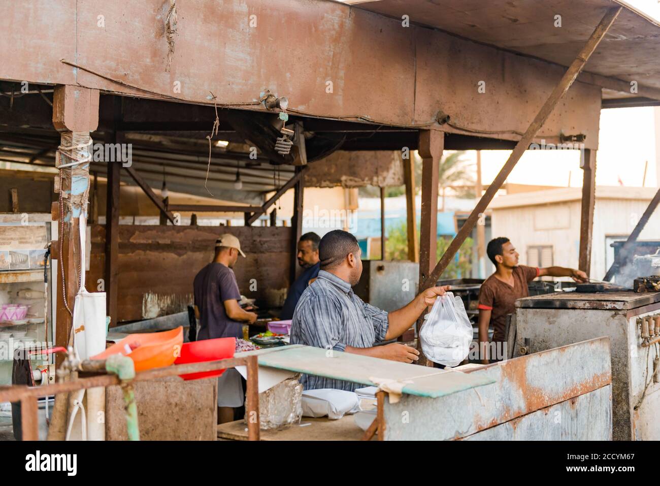 lavoratore egiziano del mercato del pesce che prepara cibo di strada sul mercato locale cucina Foto Stock