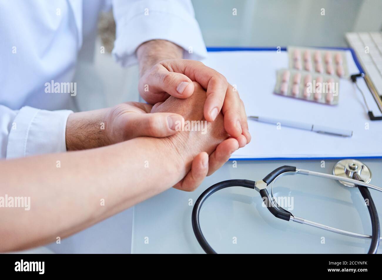 Il medico femminile tiene la mano del paziente nelle sue mani come un concetto di comfort e sicurezza Foto Stock
