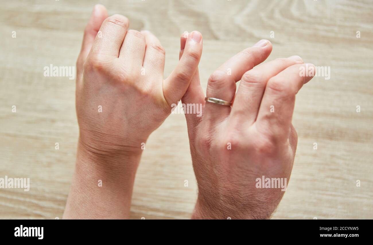 Le mani di una donna e di un uomo con un l'anello di nozze tocca con tenerezza Foto Stock