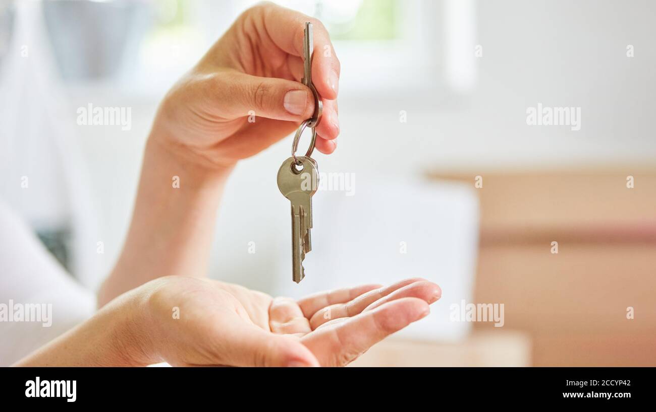 Le mani del nuovo proprietario tengono le chiavi che simboleggiano l'acquisto della casa e. proprietà Foto Stock