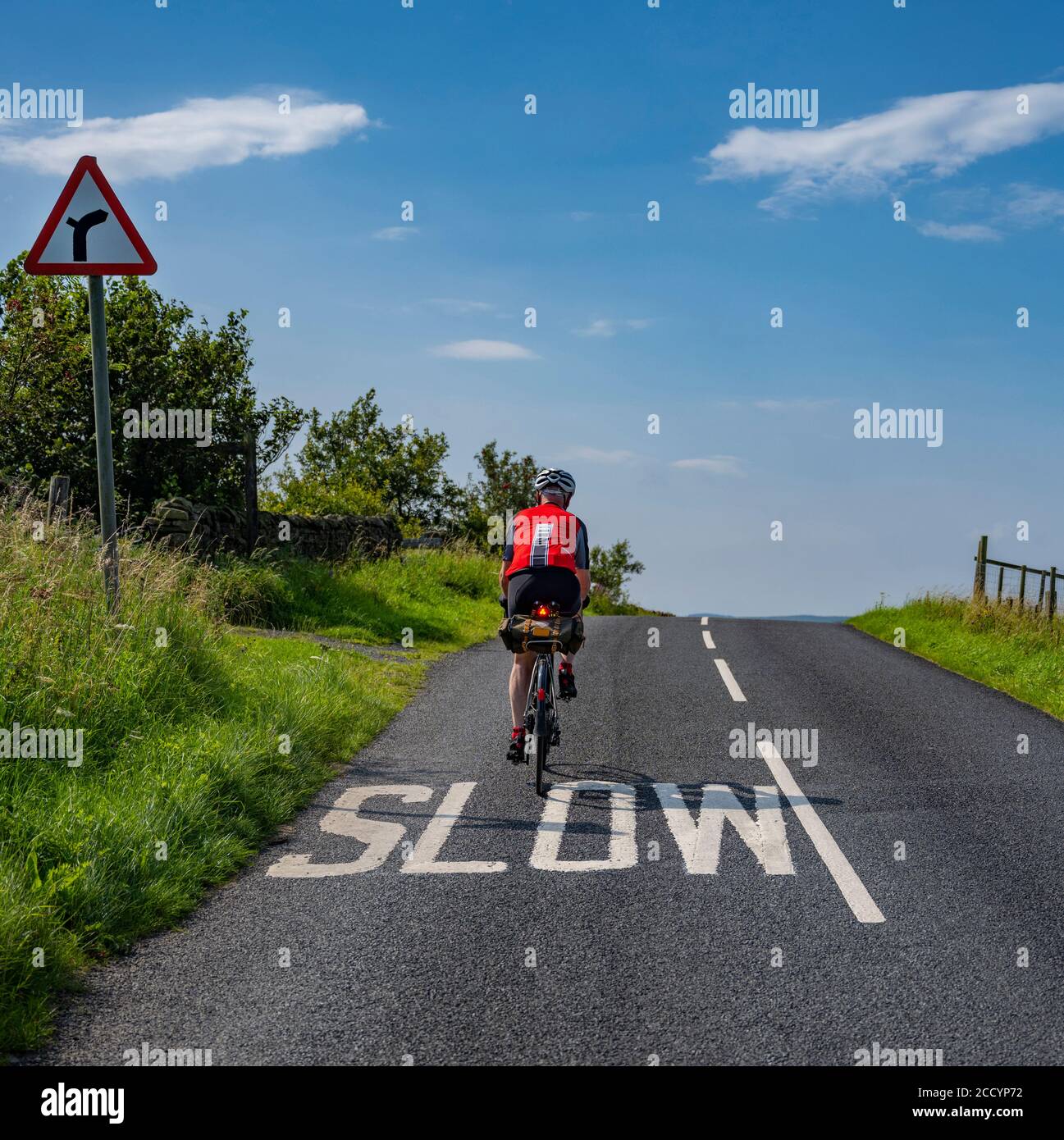 Il ciclista maschile crestando una piccola collina a Bowland, Lancashire, Regno Unito. Foto Stock
