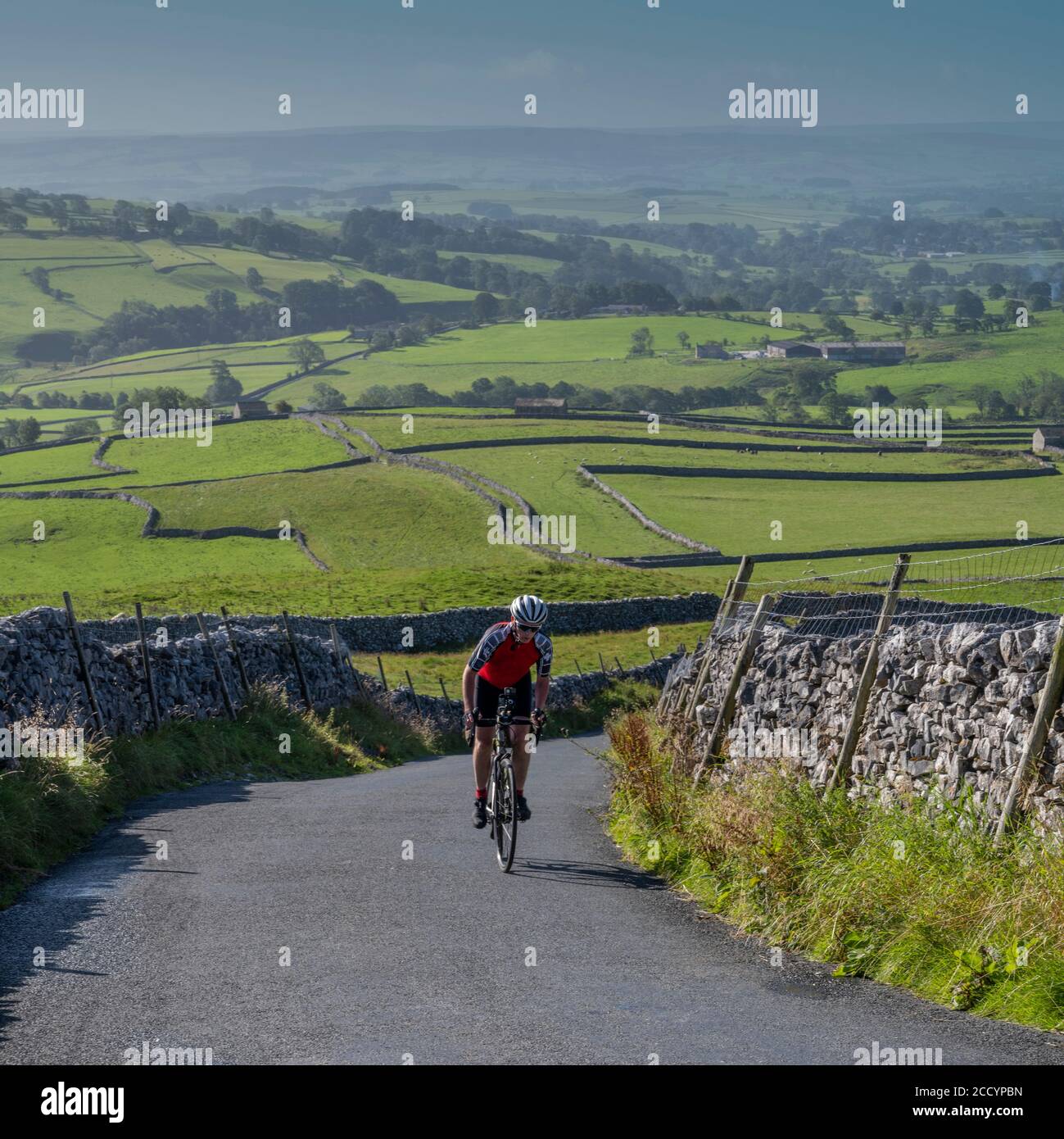 Arrampicata maschile ciclista la famosa Malham Cove Road Climb, Yorkshire Dales National Park, Regno Unito. Foto Stock