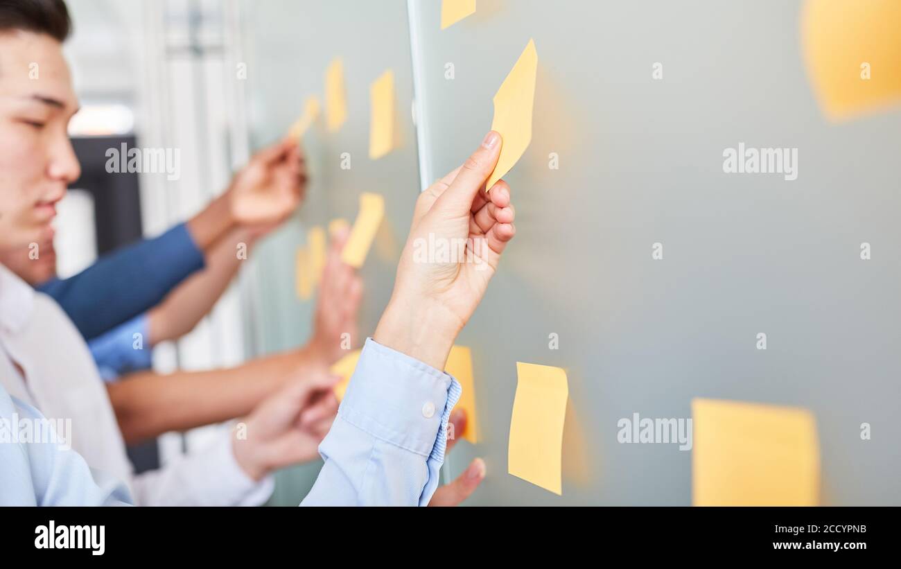 Il team aziendale raccoglie idee creative su pezzi di carta in un seminario di brainstorming Foto Stock