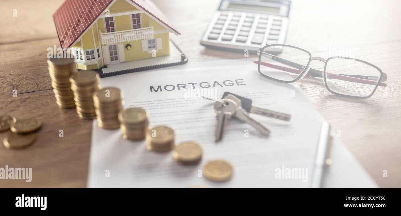 Contratto ipotecario per l'acquisto o la vendita di un appartamento o di un immobile. Scrivania con calcolatrice e penna a monete contract Foto Stock