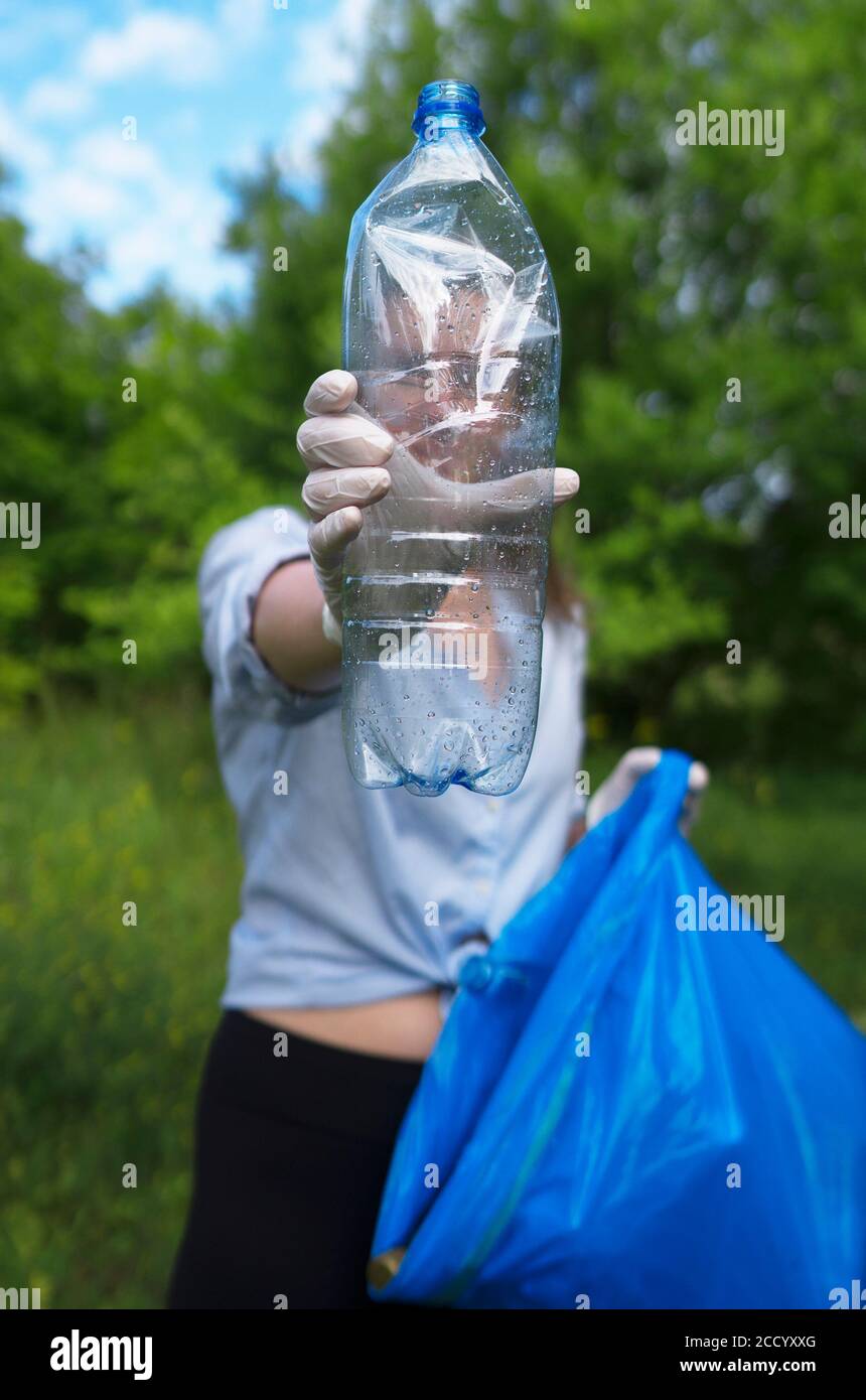 Volontario che tiene bottiglia di plastica. Concetto di inquinamento ambientale. Foto Stock