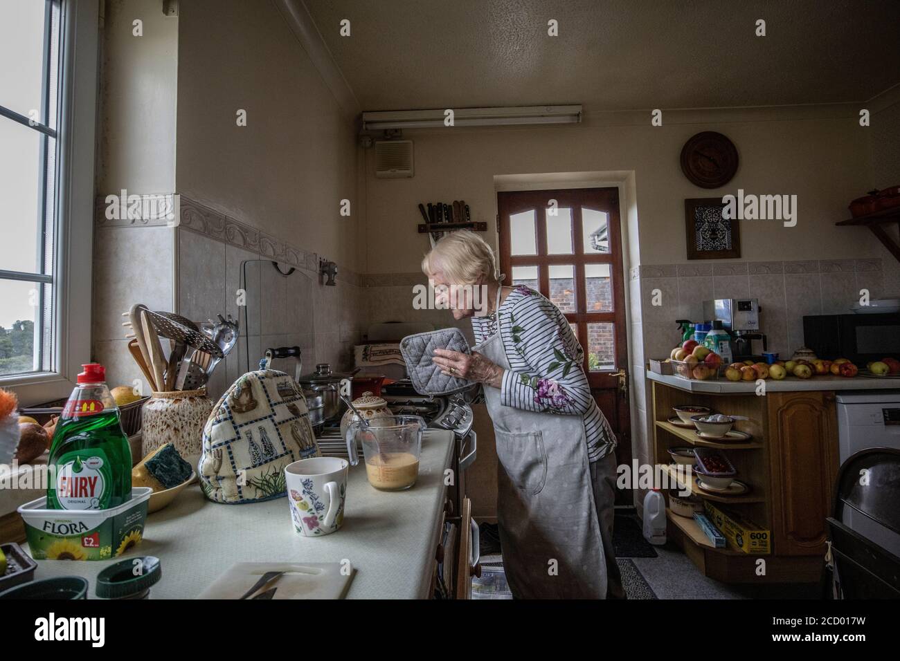 Pensionato che prepara la cena nella sua cucina, Galles, Regno Unito Foto Stock