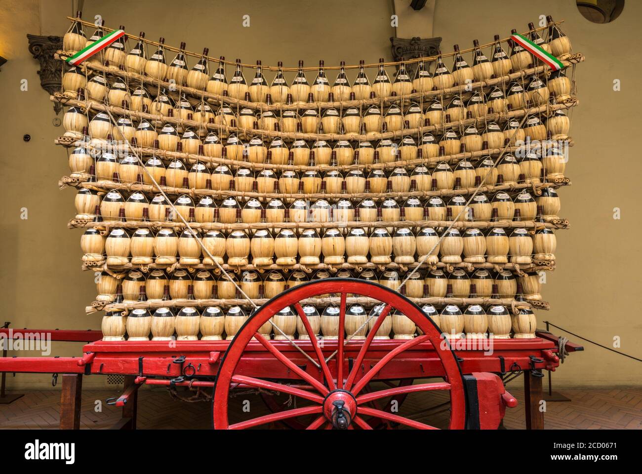 Un grande carro rosso pieno di fiasche di vino Chianti (il cosiddetto Crazy Cart) parcheggiato in un cortile di Firenze Foto Stock