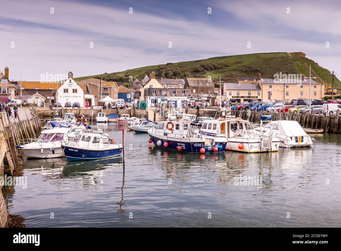 Barche ormeggiate a West Bay Harbour, Bridport, Dorset, Inghilterra, Regno Unito con East Cliff sullo sfondo. Foto Stock