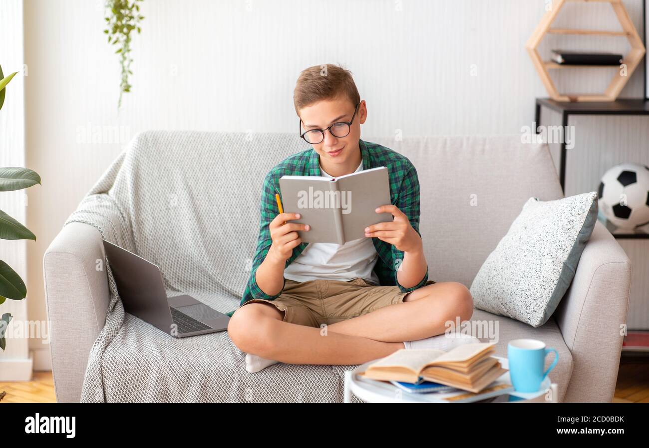 Adolescente intelligente che studia a casa, leggendo il libro Foto Stock