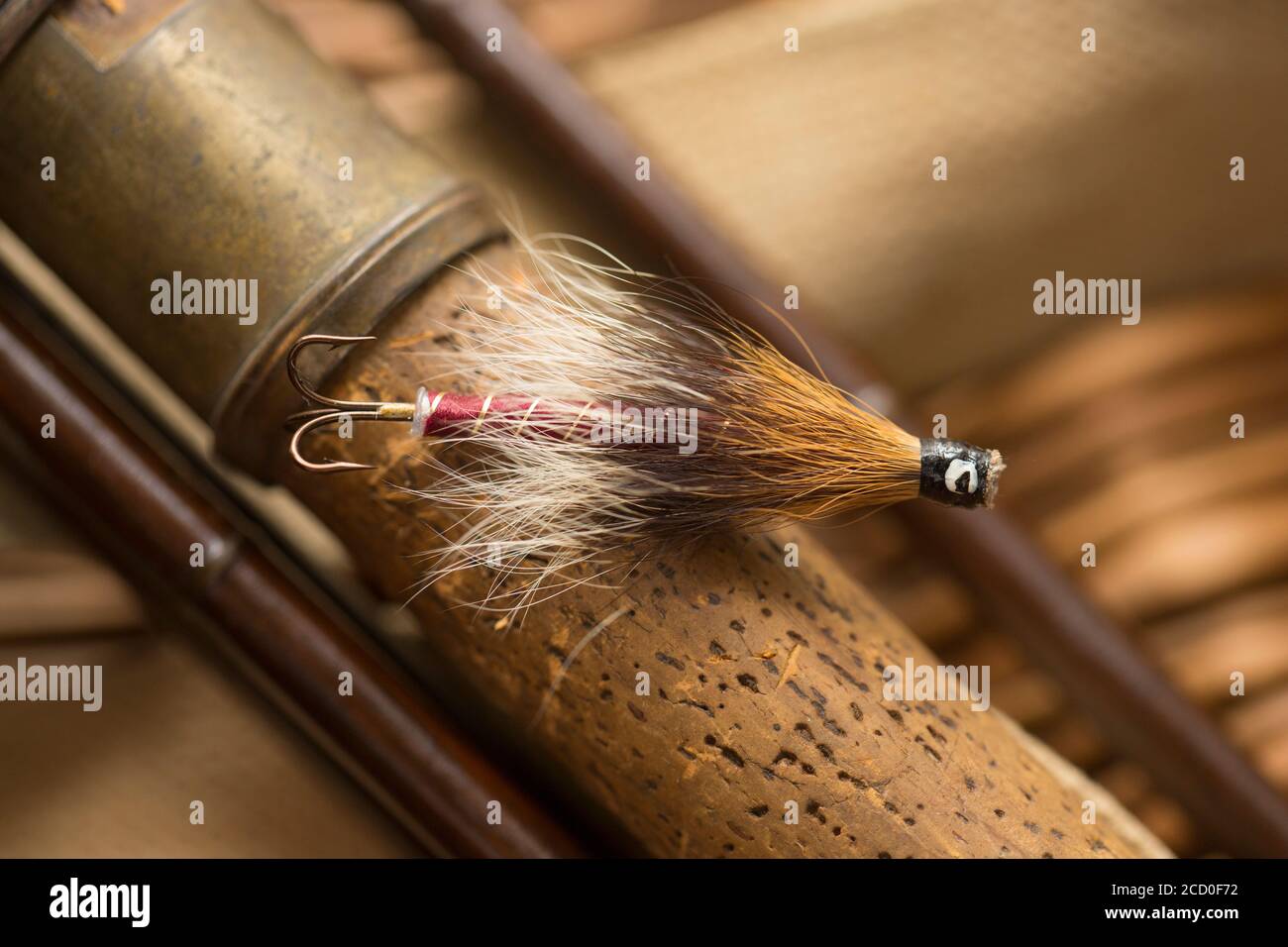 Una singola mosca di salmone che probabilmente era fatta in casa sul manico di sughero di una vecchia canna di pesca di mosca di salmone di legno. Da una collezione di attrezzatura da pesca d'epoca Foto Stock