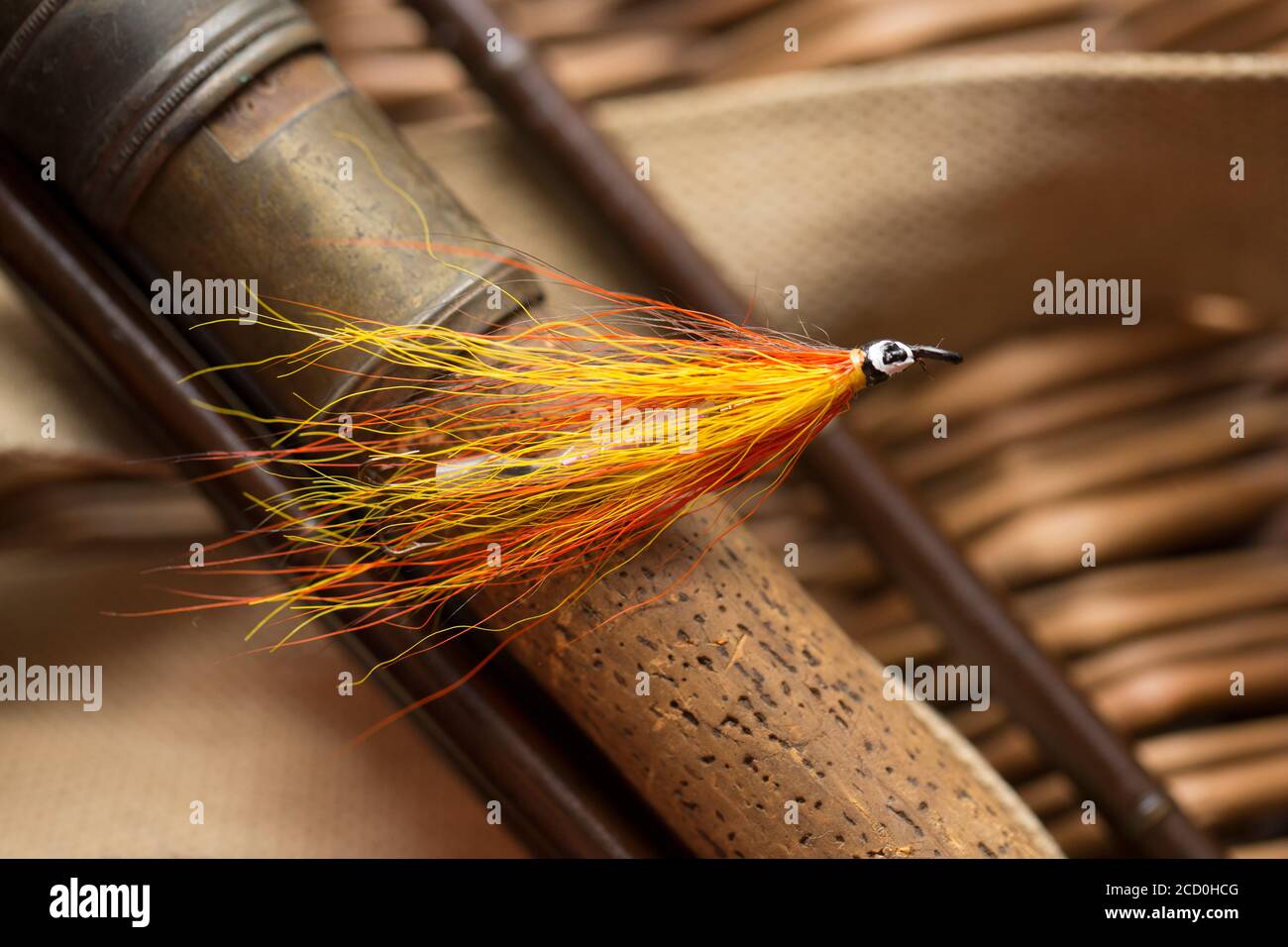 Una singola mosca di salmone che probabilmente era fatta in casa sul manico di sughero di una vecchia canna di pesca di mosca di salmone di legno. Da una collezione di attrezzatura da pesca d'epoca Foto Stock