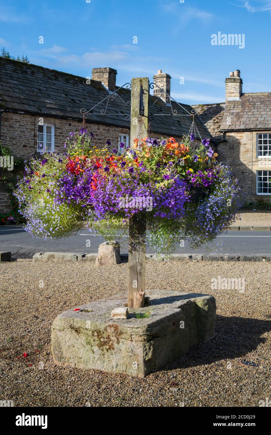 Cestini appesi e mostra floreale nel villaggio di Blanchland Northumberland Foto Stock