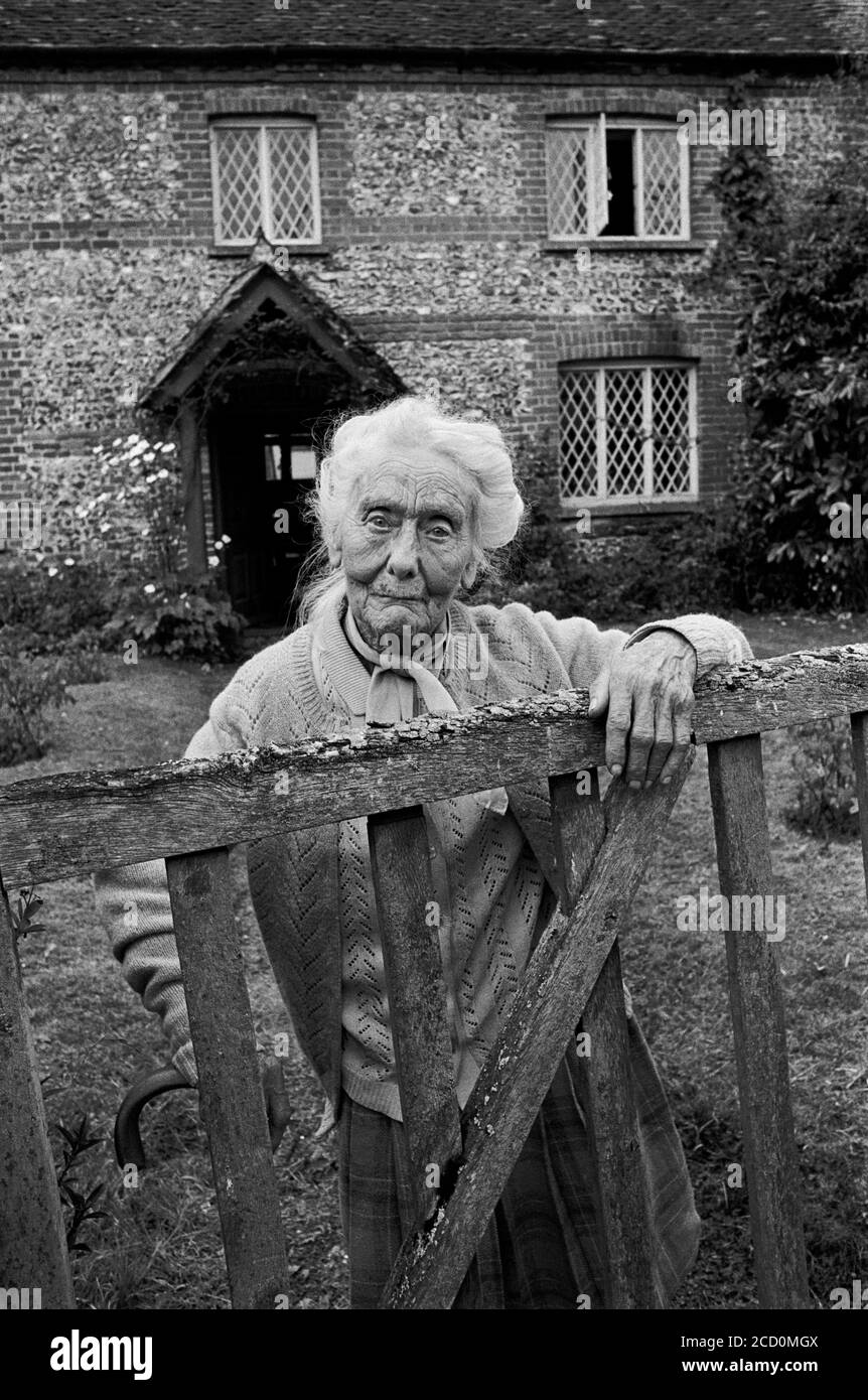 Signora di 100 anni fuori del suo cottage nel villaggio di Broughton, Hampshire, Regno Unito, 1984 Foto Stock