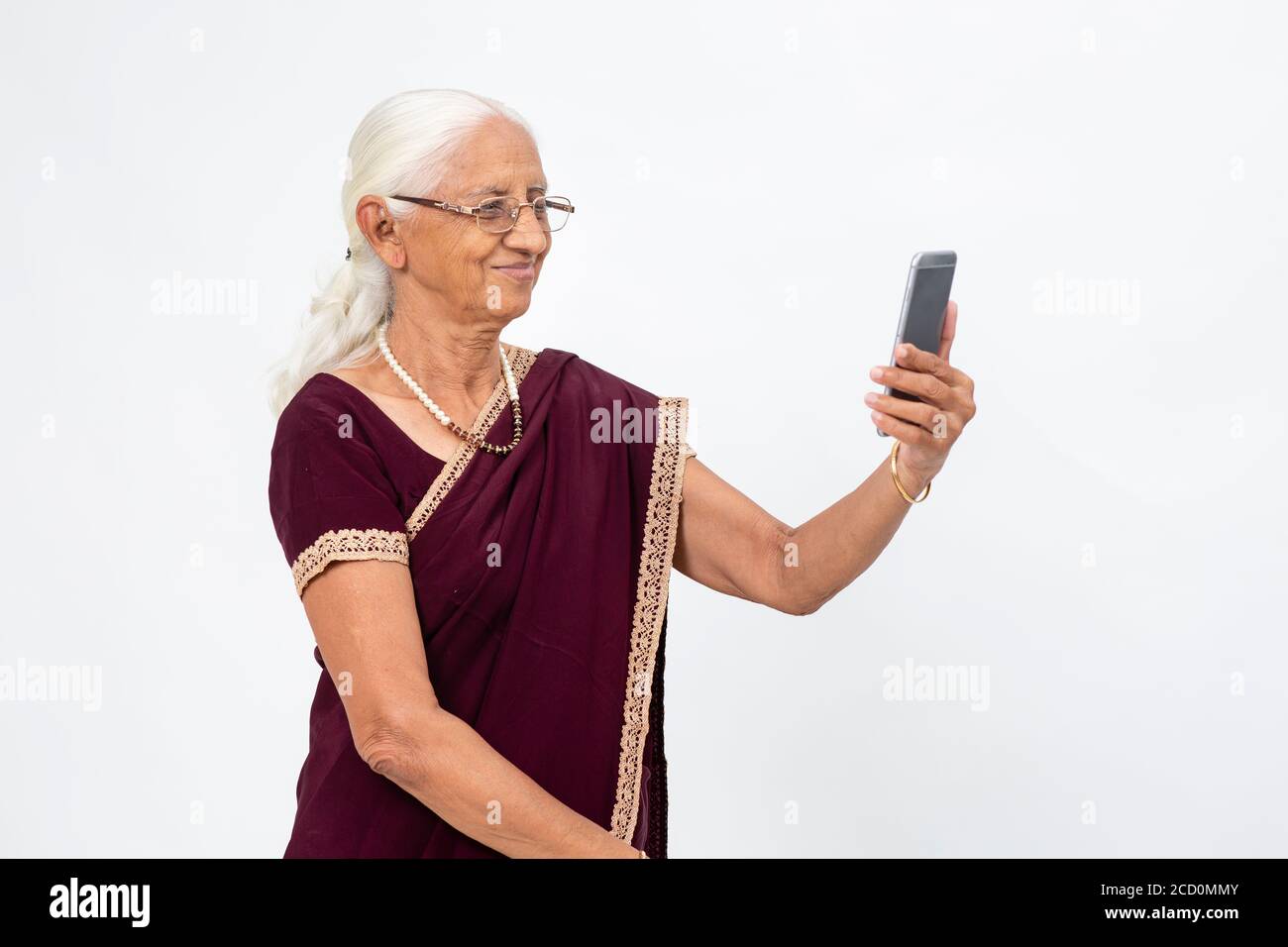 La signora indiana matura prende un selfie dal suo telefono. Donna anziana che usa il suo telefono cellulare per scattare una foto. Foto Stock