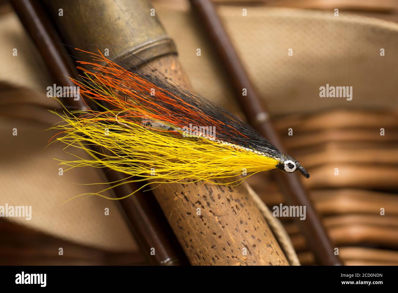 Una singola mosca di salmone che probabilmente era fatta in casa sul manico di sughero di una vecchia canna di pesca di mosca di salmone di legno. Da una collezione di attrezzatura da pesca d'epoca Foto Stock