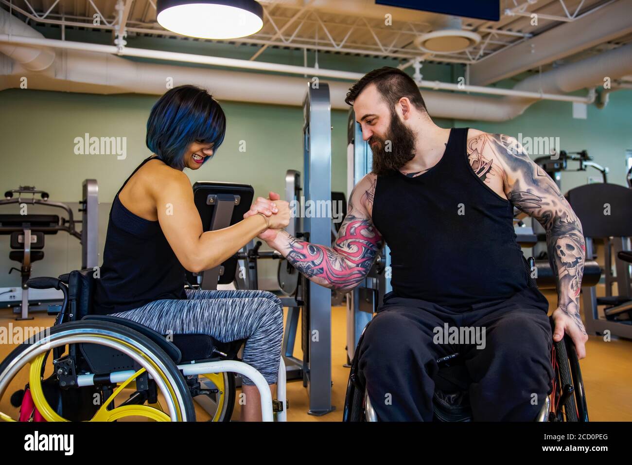 Due amici paraplegici che fingono di lottare con le braccia dopo essersi allenati in una palestra: Sherwood Park, Alberta, Canada Foto Stock