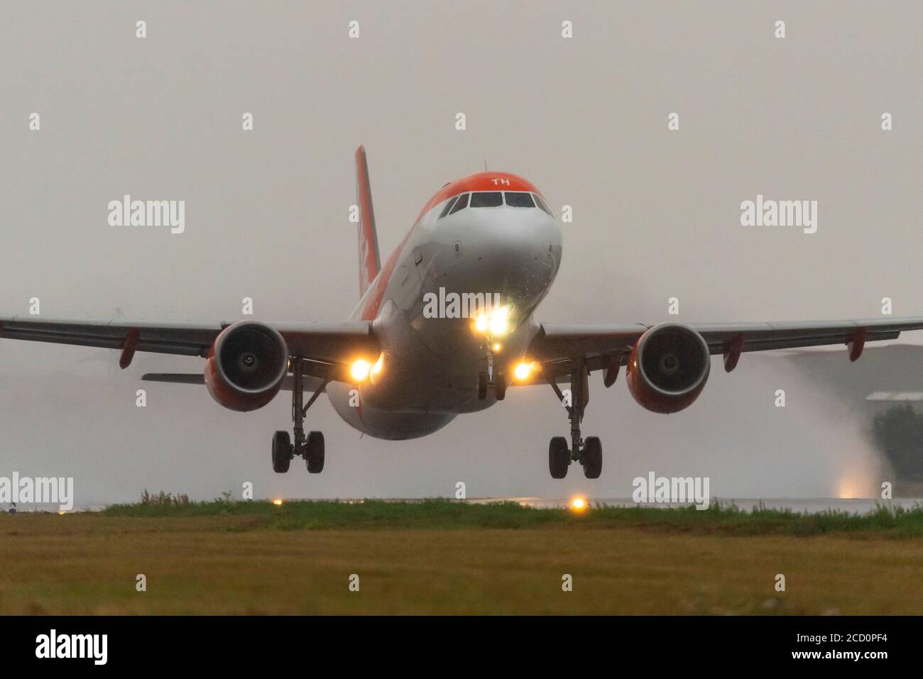 Aereo di linea easyJet che decollo all'aeroporto Southend di Londra, Essex, Regno Unito, in forte pioggia, producendo una nuvola di umidità spray dalla pista umida Foto Stock
