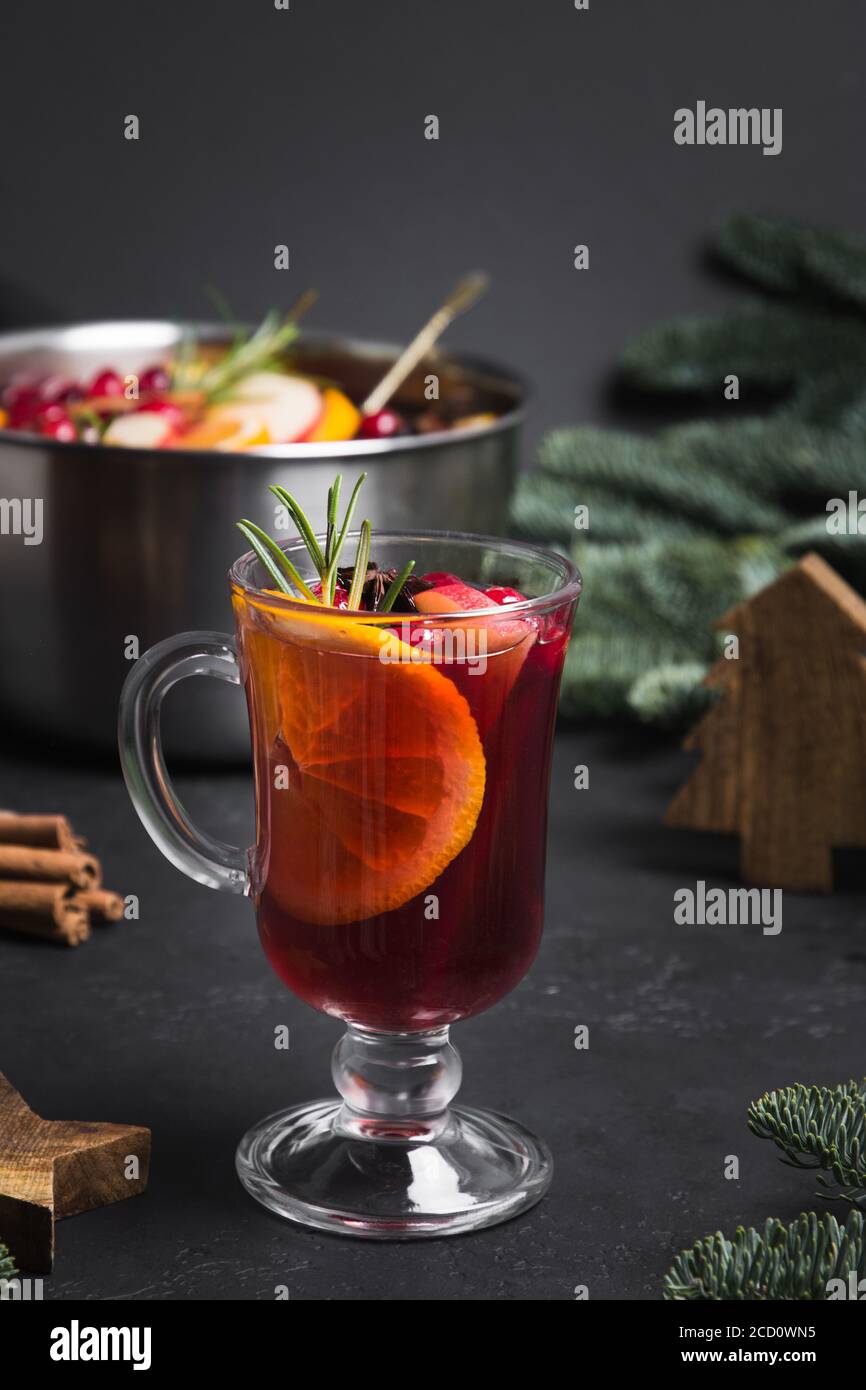 VIN brulé in vetro con sprig di rosmarino con guarnitura arancio. Festa di Natale bevanda tradizionale. Foto Stock