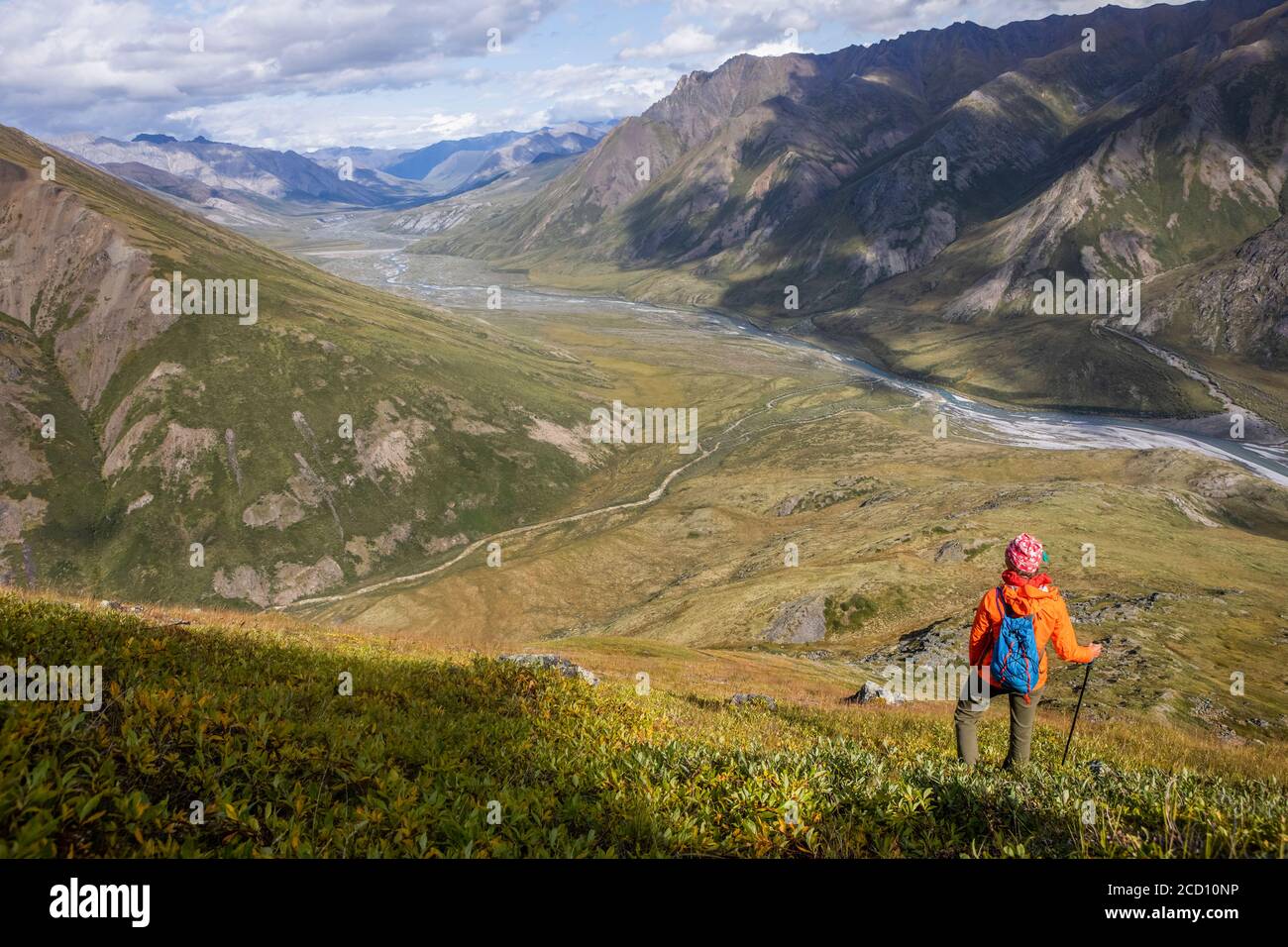 Donna escursionista indossando impermeabile arancione e zaino blu prendere in vista dall'alto delle montagne circostanti e Marsh Fork fiume e tributari... Foto Stock