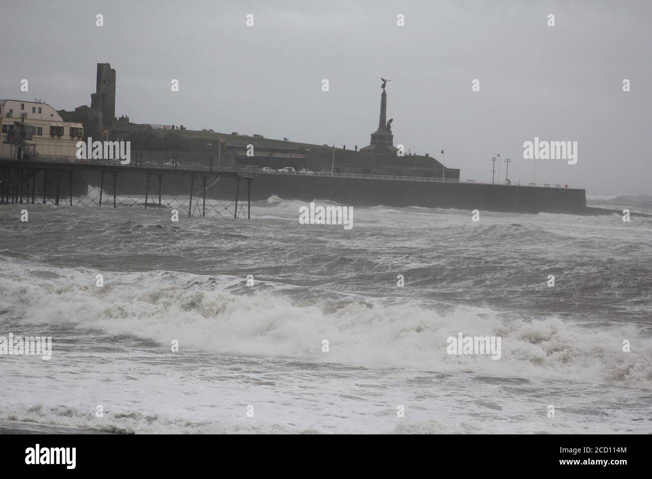 Aberystwyth Wales UK Weather 25 agosto 2020 : forti piogge e venti di Gale Force battter regioni costiere del Galles, forti venti guidare in enormi onde che sconfinano contro le difese marine di Aberystwyth. I vacanzieri coraggiosi venti di forza gale durante una passeggiata pomeridiana tempesta lungo la passeggiata, Credit: mike davies/Alamy Live News Foto Stock