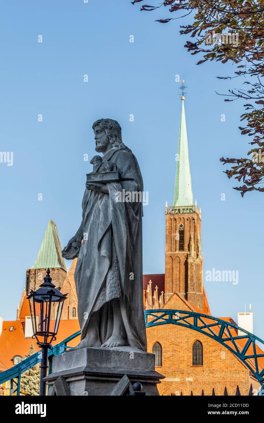 Statua di San Giovanni Battista sul ponte Tumski con la Chiesa della Santa Croce (Collegiata della Santa Croce e San Bartolomeo) nel ... Foto Stock