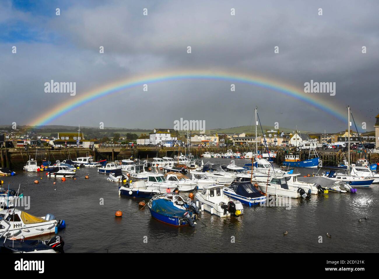 West Bay, Dorset, Regno Unito. 25 agosto 2020. Regno Unito Meteo. Un arcobaleno brilla sul porto presso la località balneare di West Bay in Dorset dopo una pesante doccia durante la tempesta Francis. Picture Credit: Graham Hunt/Alamy Live News Foto Stock