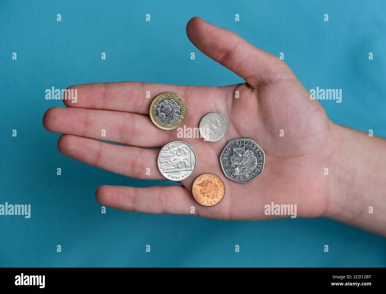 Monete britanniche tenute in palmo di mano Foto Stock