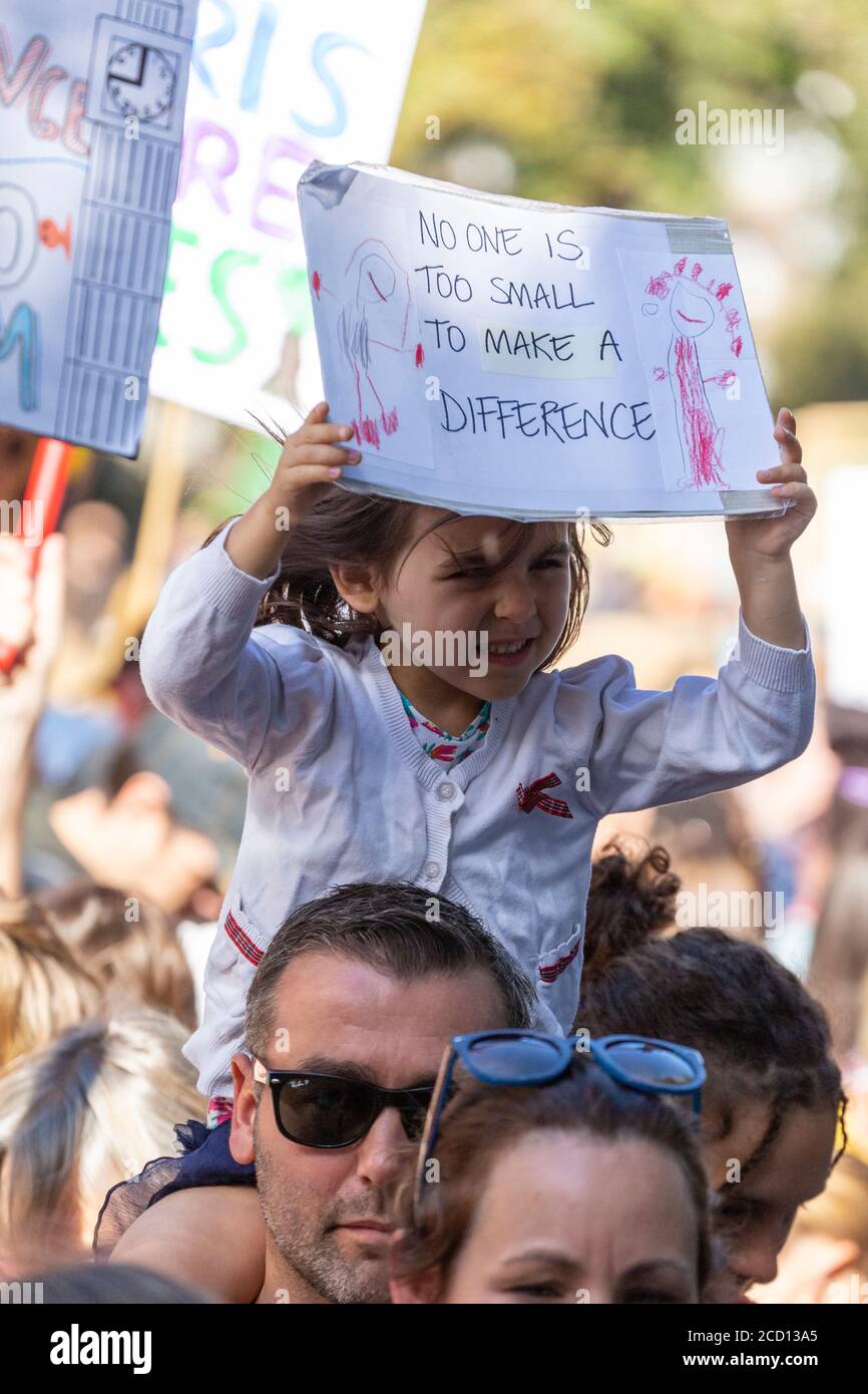Una giovane ragazza che cavalca il piggyback e che tiene un segno di protesta durante lo Sciopero climatico, Londra, 20 settembre 2019 Foto Stock
