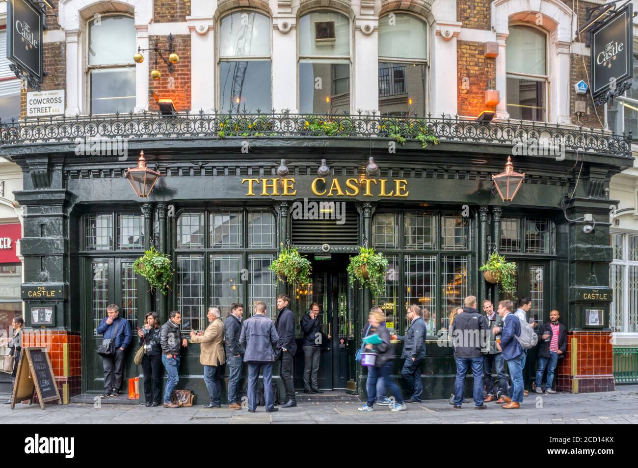 Persone che bevono fuori dal pub Castle in Cowcross Street, Londra. Segno pawnbroker si riferisce alla licenza emessa da re Giorgio IV all'inizio del 19th ° secolo. Foto Stock