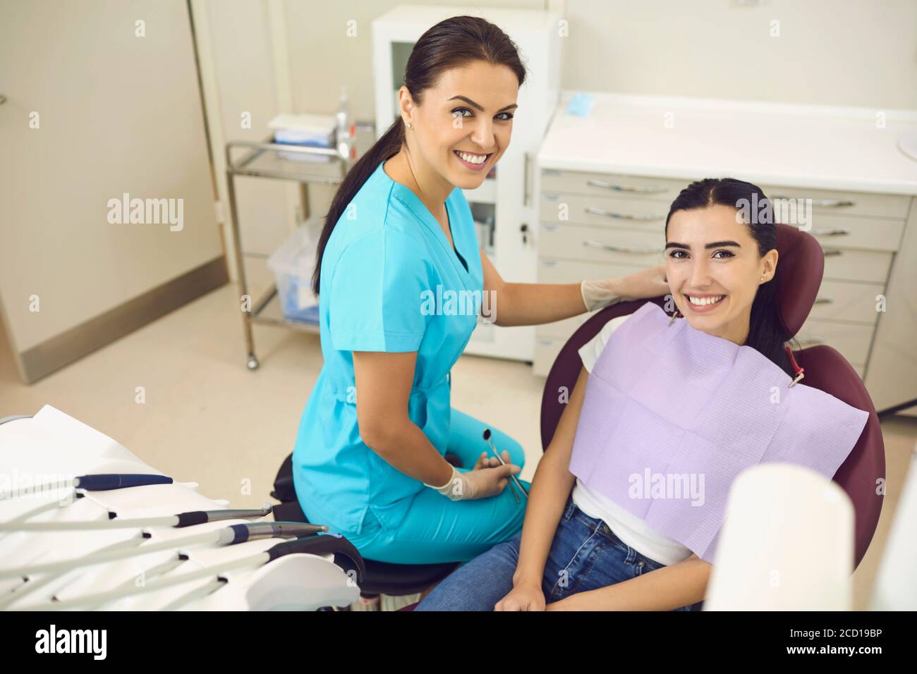 Sorridente dentista e paziente donna che guarda la macchina fotografica in dentista clinica durante la consultazione Foto Stock