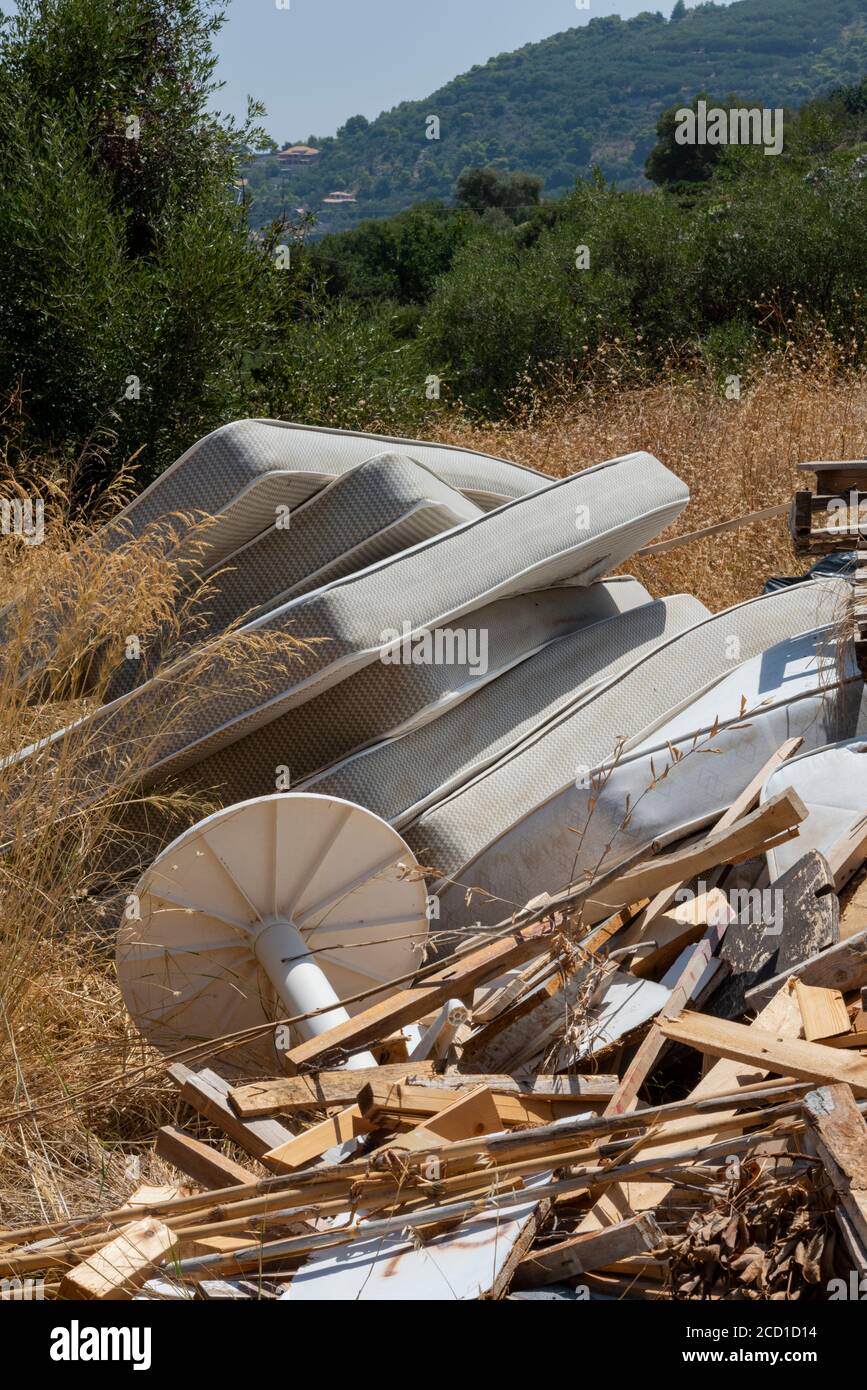 vecchi materassi e letti con tavoli e sedie volano ribaltati e volano ribaltando in campagna in grecia su zante. Foto Stock