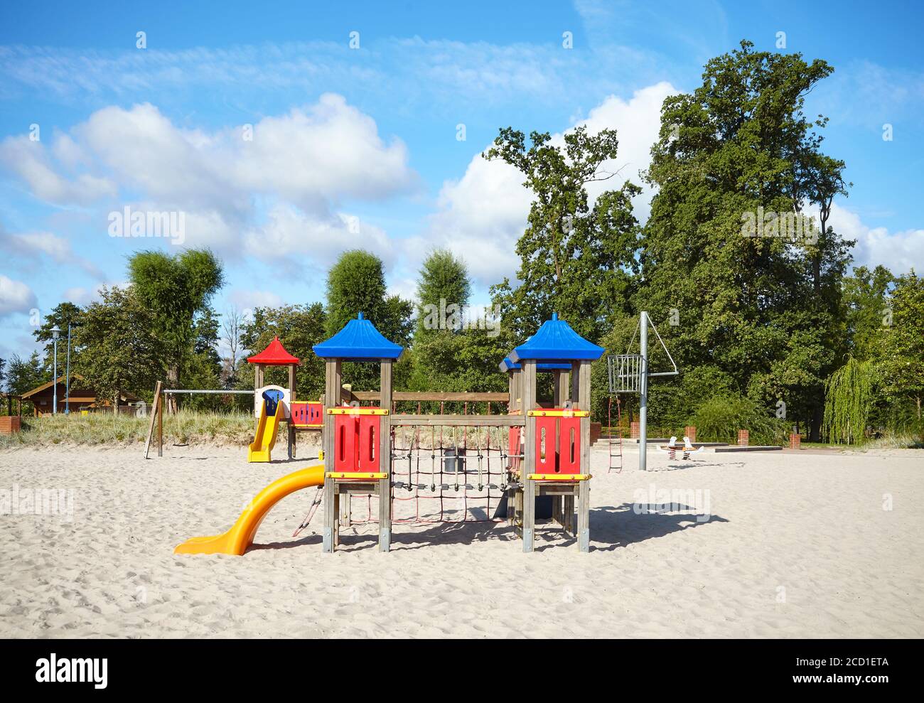 Parco giochi all'aperto vuoto su una spiaggia in una giornata di sole. Foto Stock