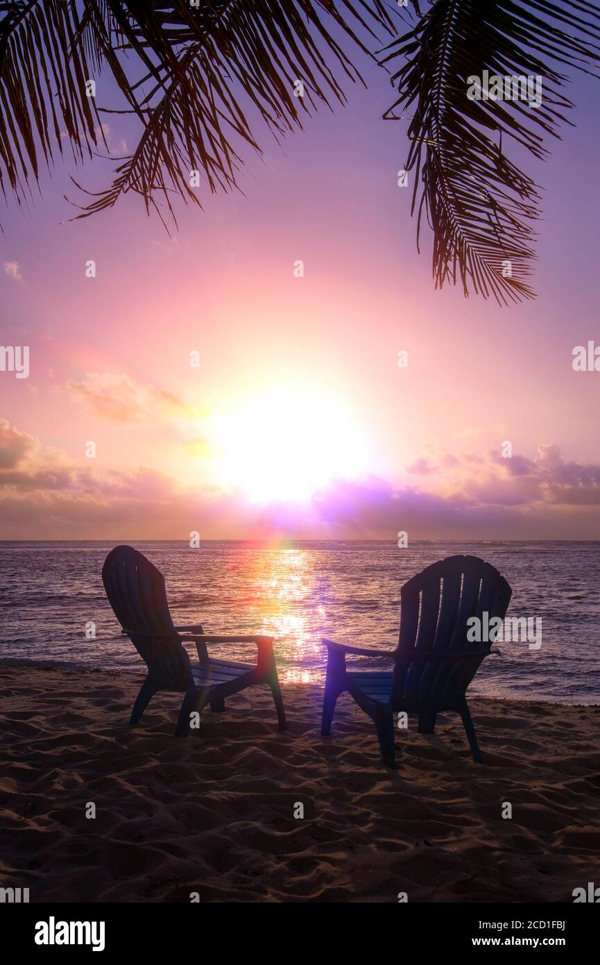 Due sedie da spiaggia con magnifici tramonti e palme Foto Stock