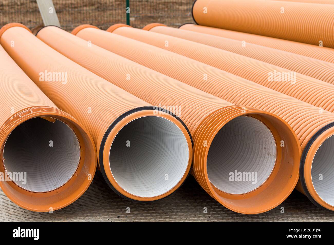 Tubi di plastica fognari di colore arancione in un cantiere. Materiali da  costruzione. Tubi per l'alimentazione dell'acqua Foto stock - Alamy