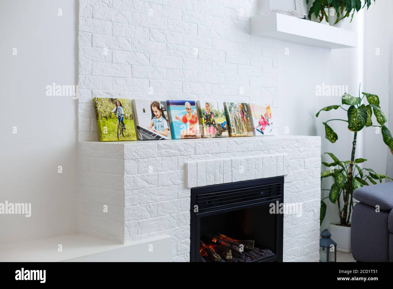 Cornici collage con poster floreali su pareti in mattoni testurizzati, su divano moderno, arredamento interno mock up Foto Stock