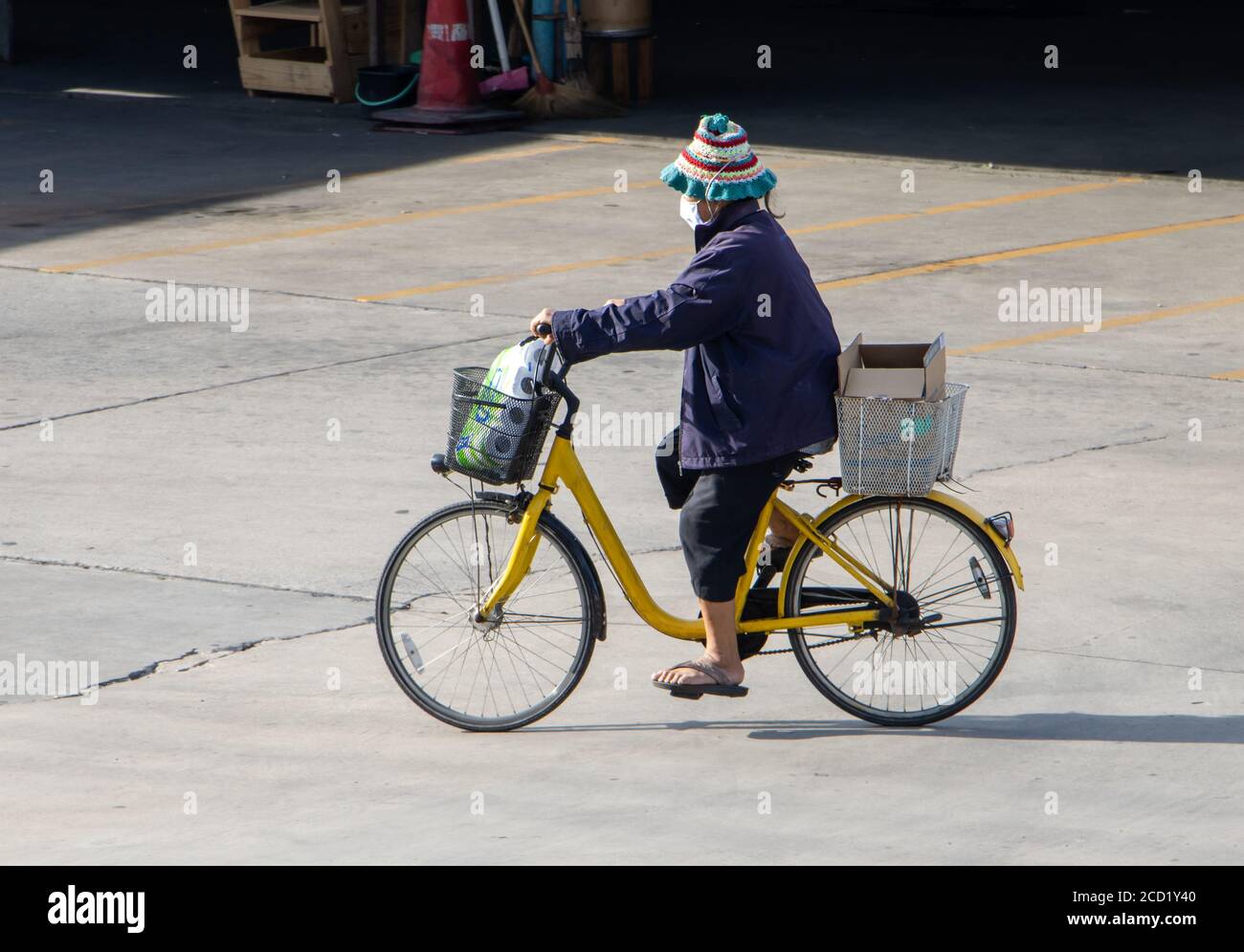 SAMUT PRAKAN, THAILANDIA, 01 2020 LUGLIO, una donna con carico corre in bicicletta in città strada. Foto Stock