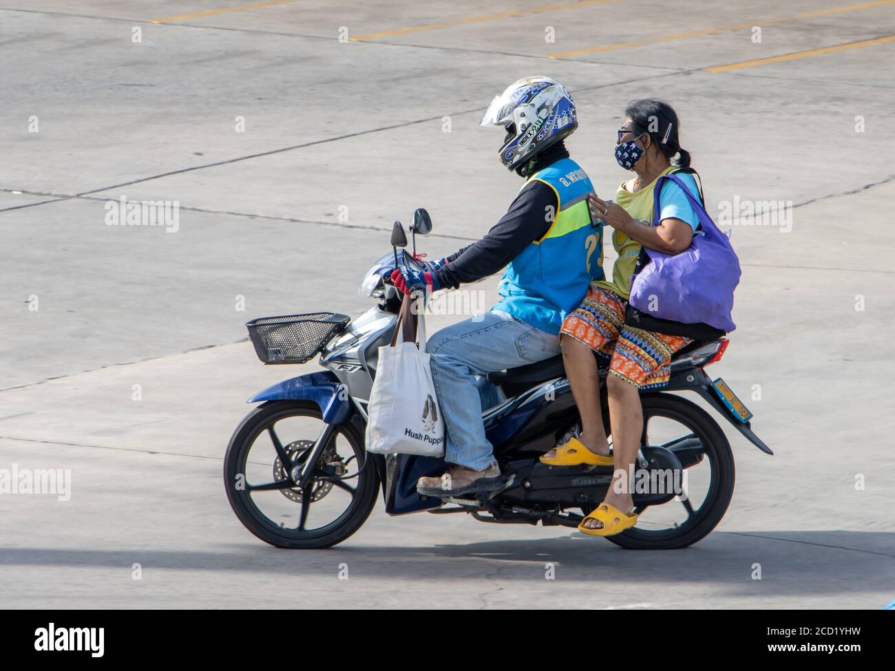 SAMUT PRAKAN, THAILANDIA, 01 2020 LUGLIO, UN tassista su una moto giri con una donna e le sue borse shopping. Il conducente del mototaxi trasporta un passeggero fra Foto Stock