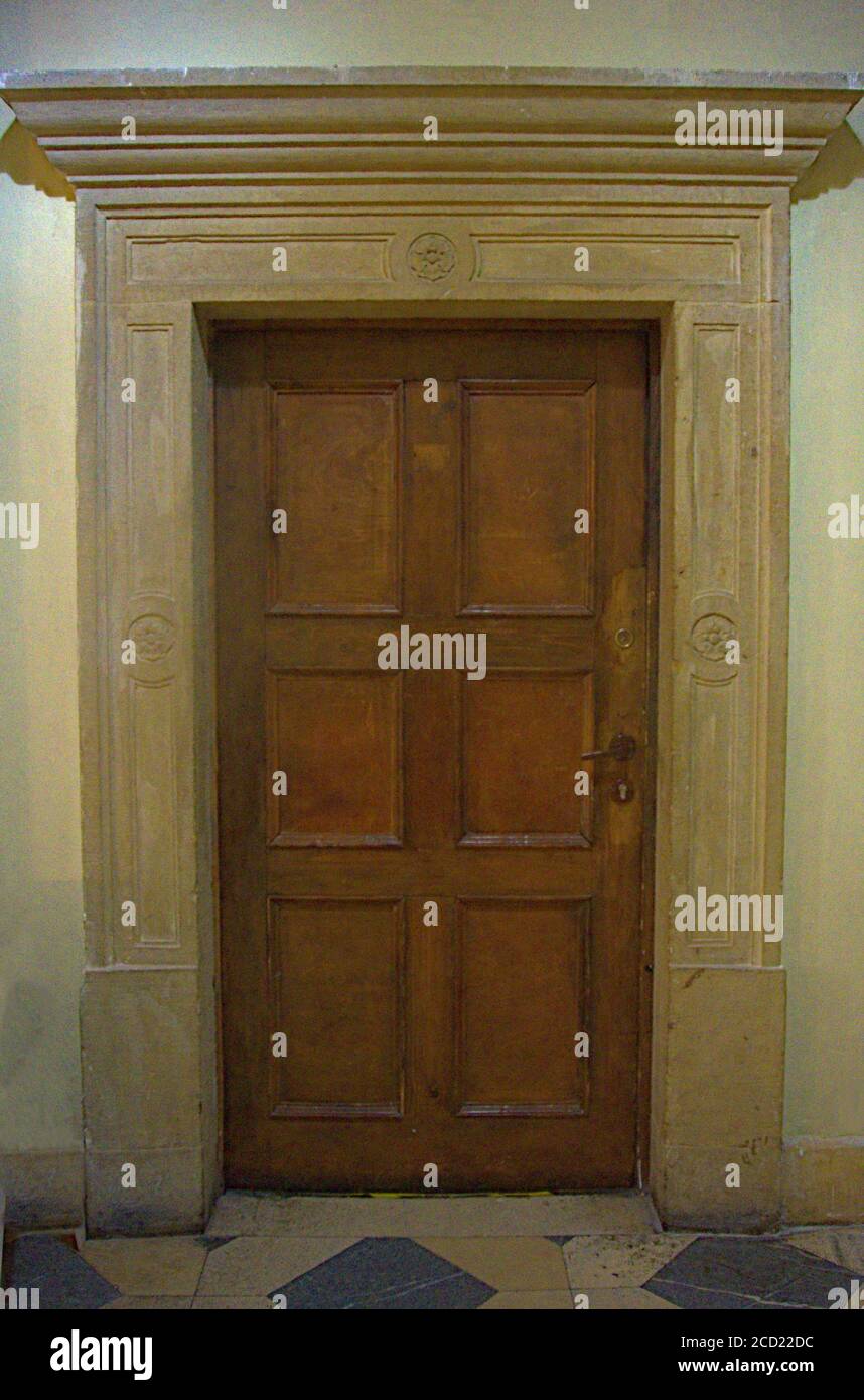 Una vecchia porta in legno con una pesante cornice in pietra Foto Stock