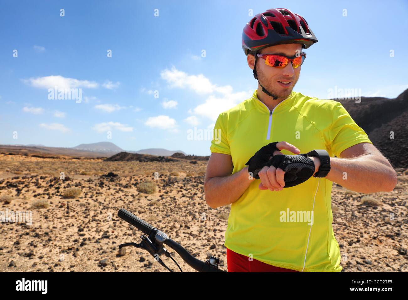 Sport fitness Watch mountain biker on mtb bike using smartwatch app for fitness challenge. Atleta giovane che usa la sua tecnologia indossabile in bicicletta Foto Stock