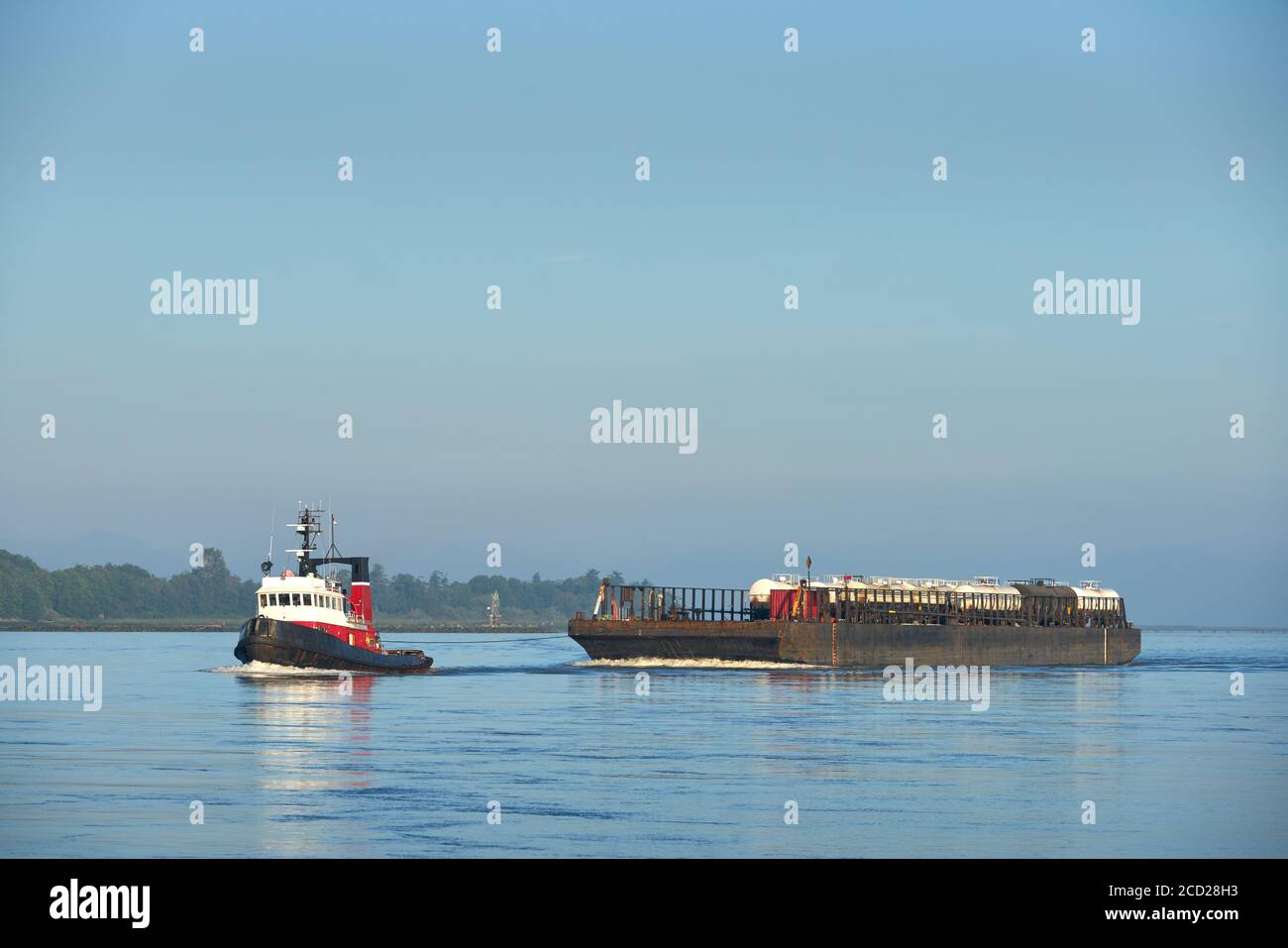 Chiatta da rimorchiatore e autolavaggio. Un rimorchiatore che traina le autocisterne su una chiatta ferroviaria sul fiume Fraser. Richmond, British Columbia, Canada. Foto Stock