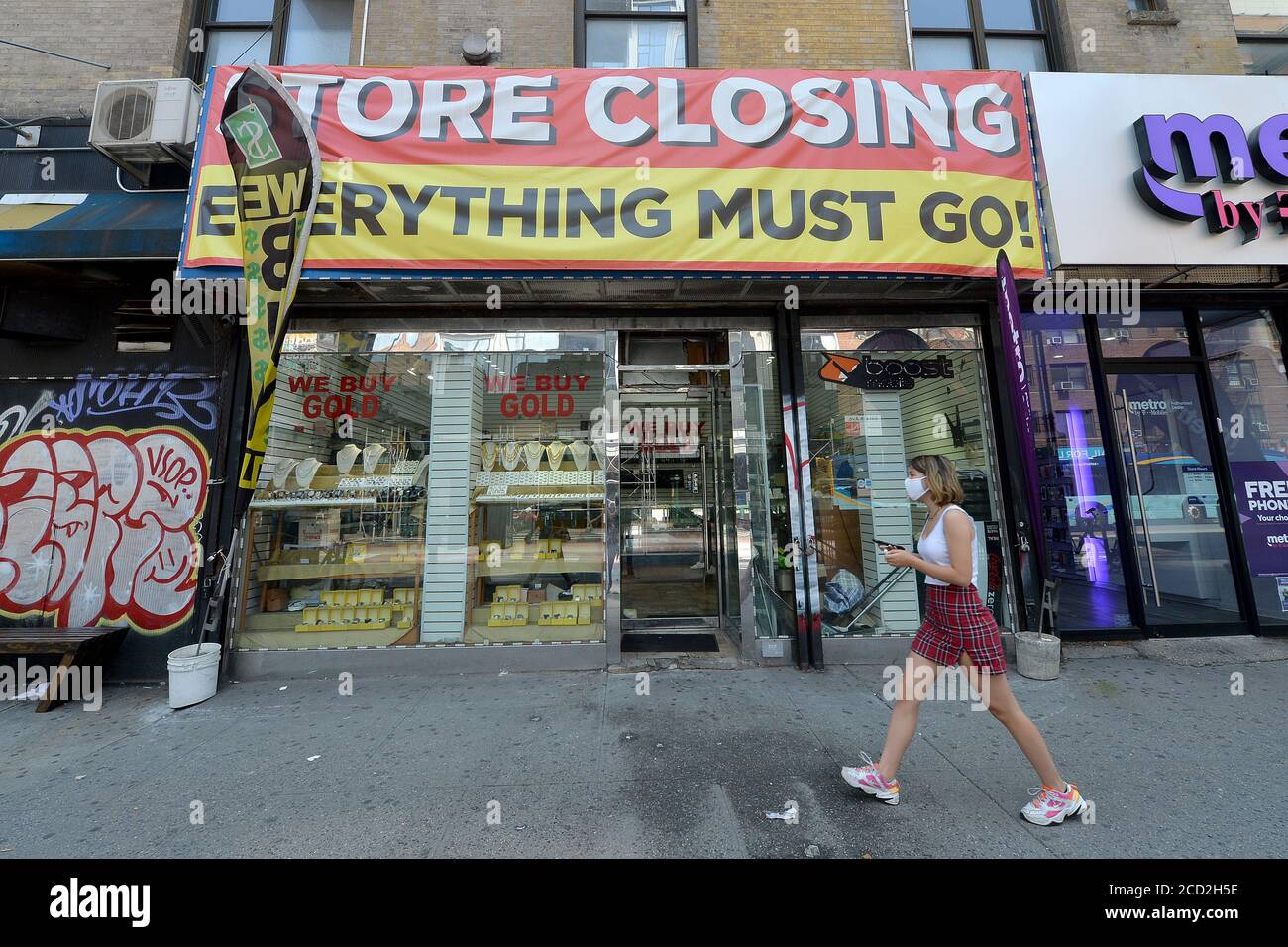 New York City, Stati Uniti. 25 Agosto 2020. Una donna passa davanti a un negozio "uscendo dal commercio" nel quartiere Chelsea di a New York, NY, 25 agosto 2020. Nonostante i miliardi di dollari in termini economici stimolati offerti dal governo federale, i negozi svuotati o svuotati in tutta New York City sono una testimonianza del continuo impatto economico della pandemia della COVID-19, con una ripresa prevista difficile come le lotte di New York City con un debito previsto di 9 miliardi di dollari. (Anthony Behar/Sipa USA) Credit: Sipa USA/Alamy Live News Foto Stock