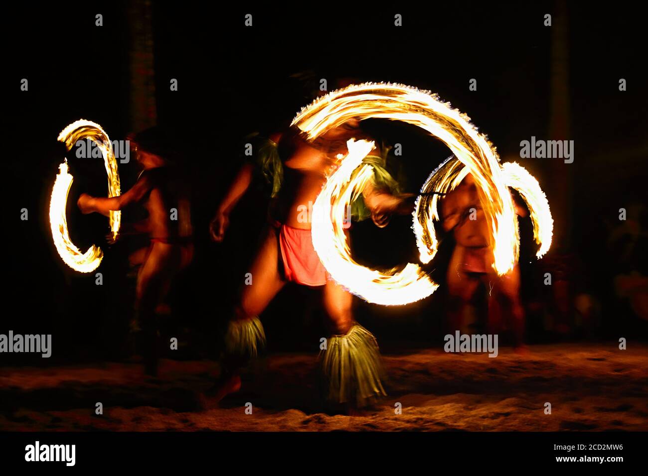 Danzatori di fuoco allo spettacolo di luau delle Hawaii, uomini polinesiani di danza hula che giocolano con torce di fuoco. Foto Stock