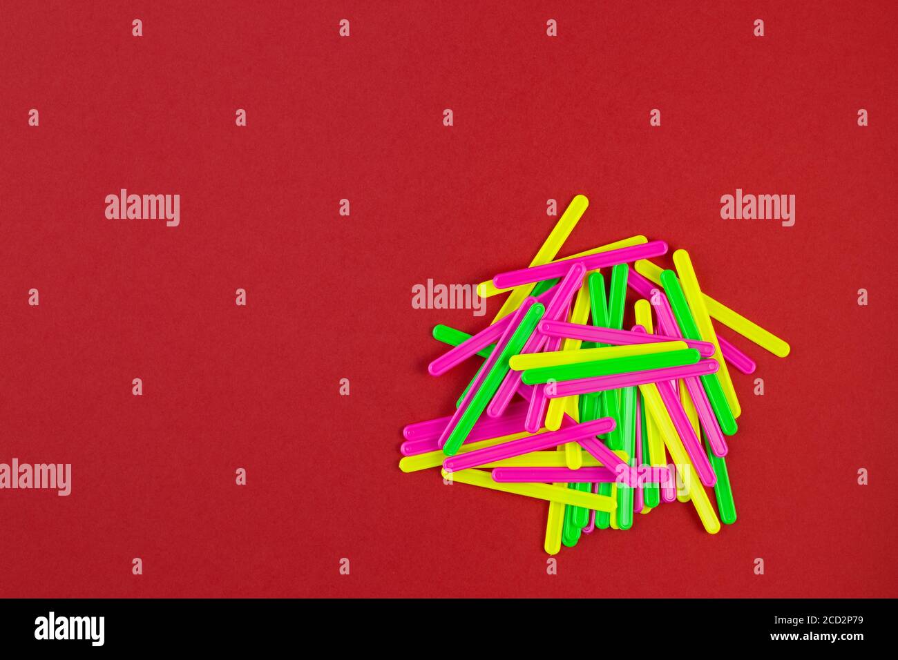 Bastoni di diversi colori per le classi con bambini su sfondo di carta rossa con spazio di copia. Cancelleria scolastica. Preparazione alla scuola con co Foto Stock