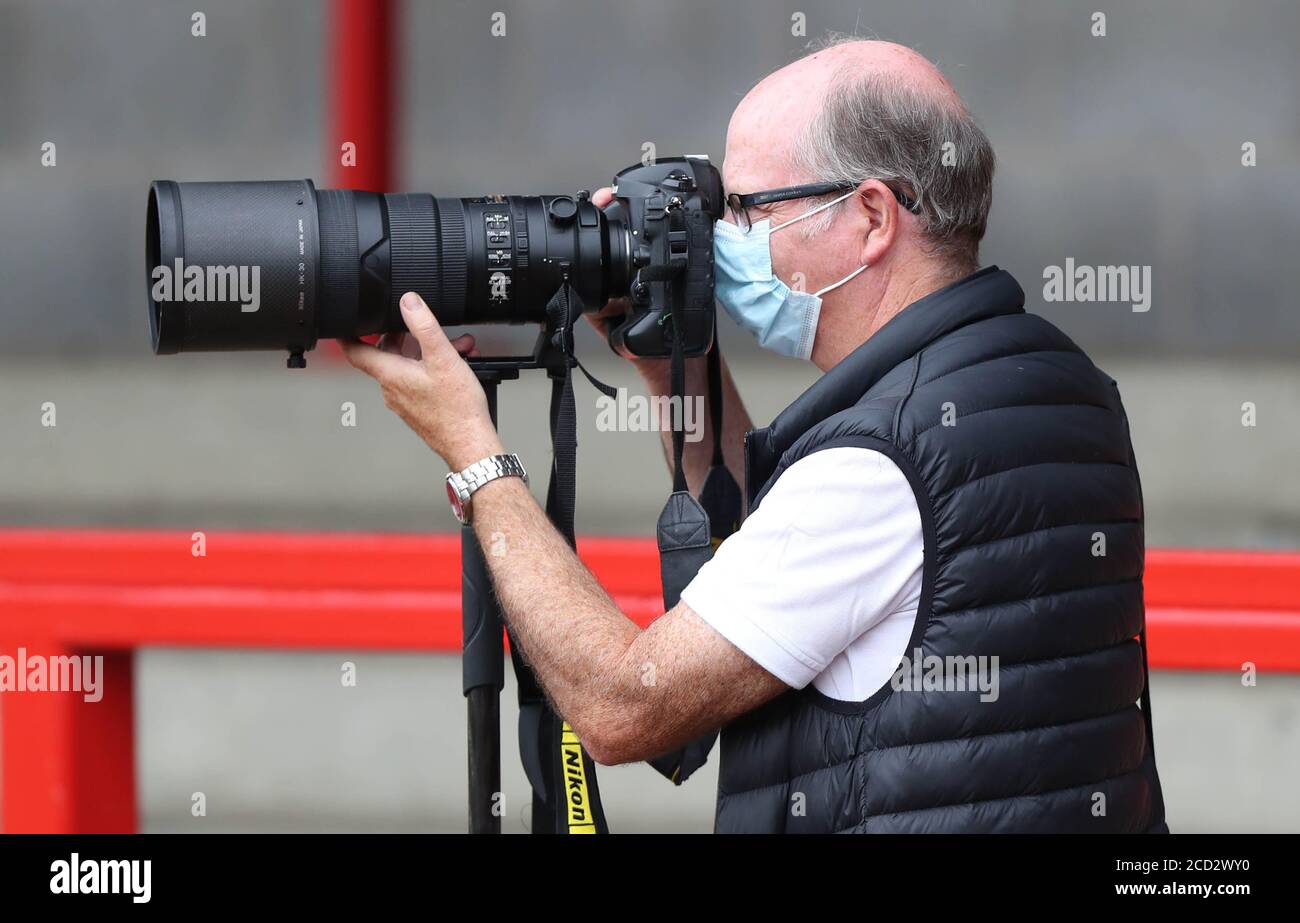 Sport fotografo Simon Dack al lavoro durante la pandemia di Coronavirus indossando una maschera al Crawley Town / Crystal Palace presso il People’s Pension Stadium. Credito: James Boardman Foto Stock